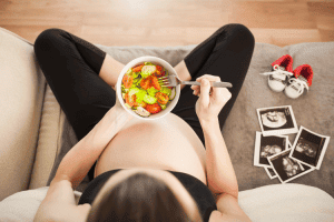 pregnant woman eating salad