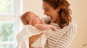 mother smiling at baby cradled in arms