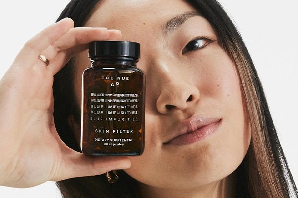ASIAN MODEL HOLDING NUE CO SKIN FILTER SUPPLEMENTS TO HER EYE