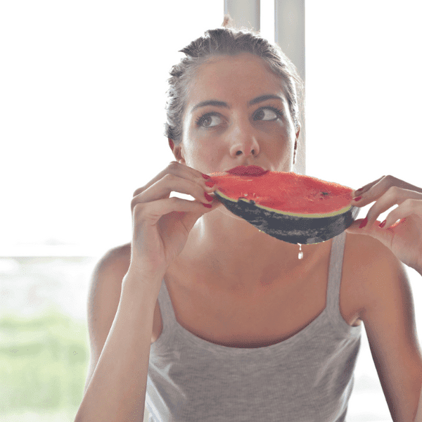 A woman eating a watermelon