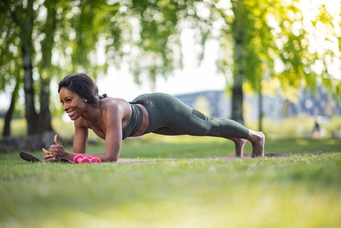 Fit woman doing plank in nature