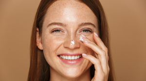 Woman applying a ceramide-rich moisturizer to her nose.