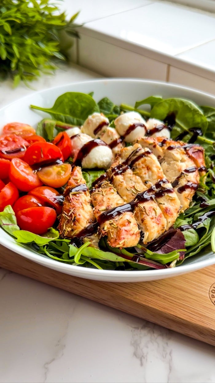 caprese chicken salad. tomatoes, chicken breast and mozzarella on a bed of leaves