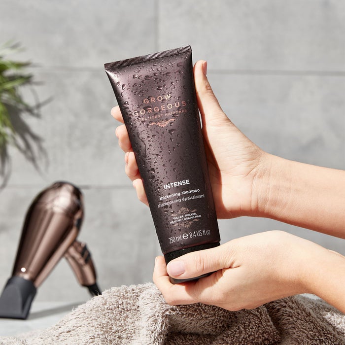 Lifestyle image of the Grow Gorgeous shampoo being held in hands. The shampoo is from the Intense range for thinning hair.