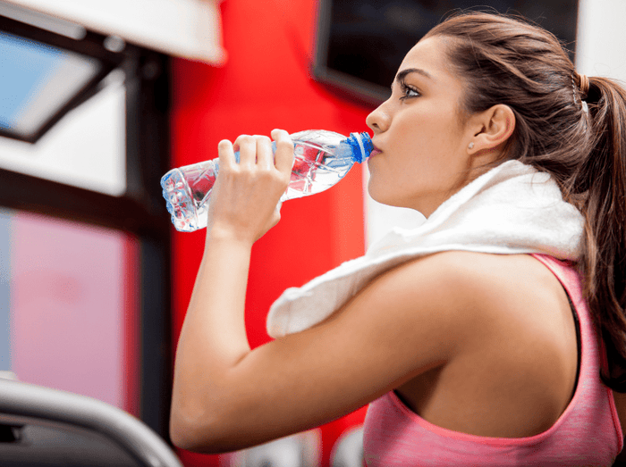woman staying hydrated at the gym