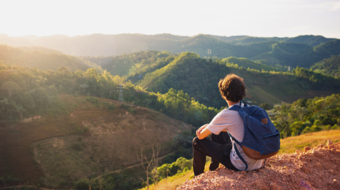 person sitting on hilltop