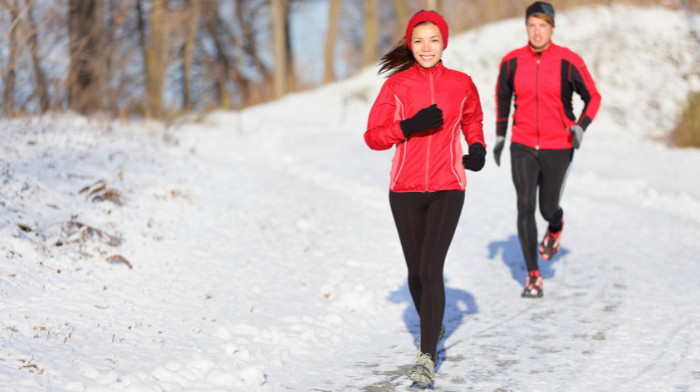 man and woman running in snow