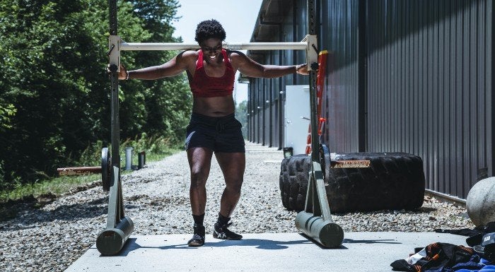 woman lifting heavy weight outside