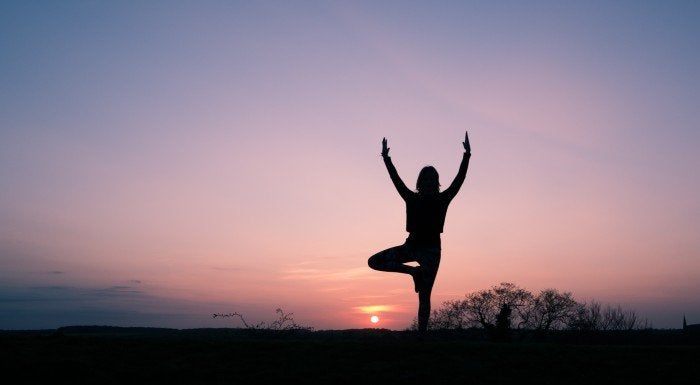 donna che fa yoga all'alba
