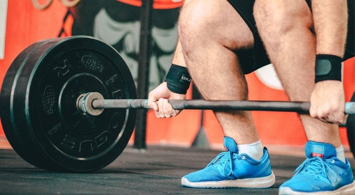 man lifting weighted bar in the gym