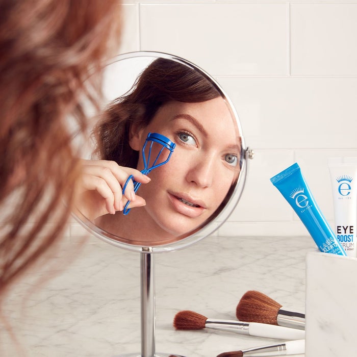 woman curling eyelashes with eyelash curler