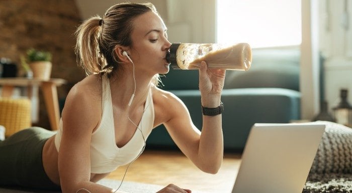 kobieta pijąca szejka, aby zwiększyć spożycie białka