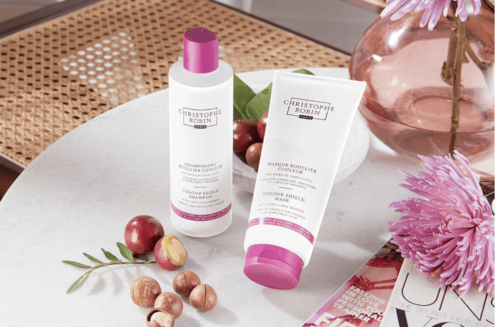 Christophe Robin's colour protect shampoo and conditioner next to camu camu berries