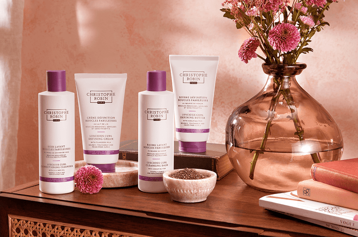 4 of the best hair care products for curly hair by Christophe Robin's Curl Enhance range. 4 white bottles with purple accents.