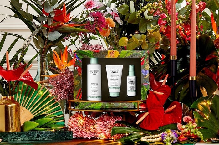 Christophe Robins hair care christmas gift sets for hydrating hair surrounded by red, orange and green flowers.