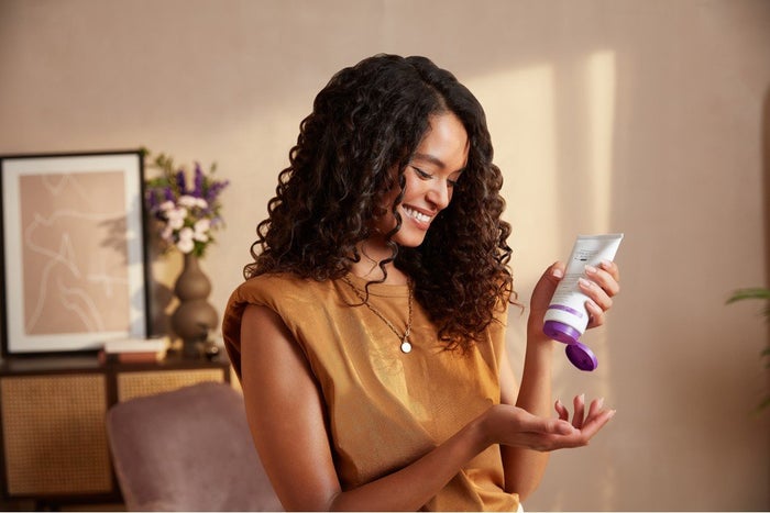 Woman with dark brown Z shaped curls using Christophe Robin's curly hair balm.