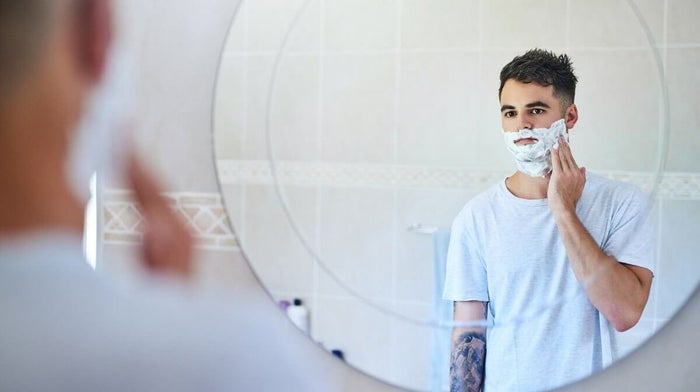 young man applying shaving foam