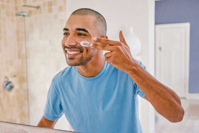 man applying moisturiser to his cheeks post-shave 