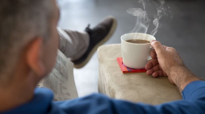 man enjoying time to himself with a cup of tea and the newspaper