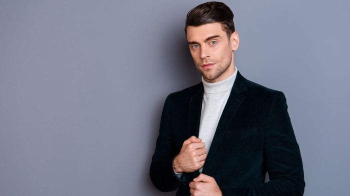 man wearing a roll neck jumper underneath a velvet blazer 