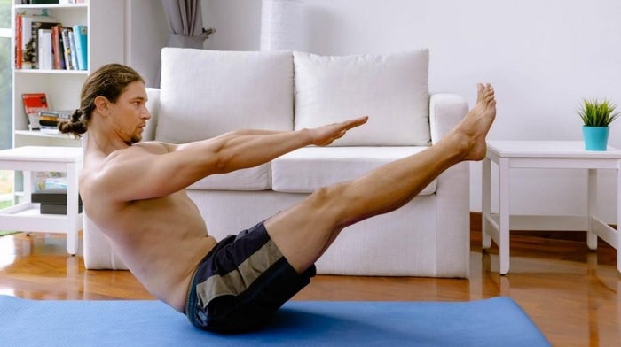 man in the boat yoga pose