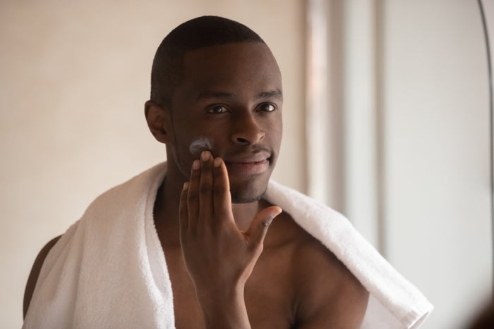 man with stubble beard applies moisturising balm 