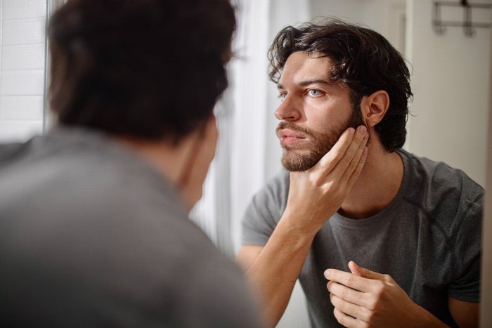 Man looking  into the mirror before trimming beard with Gillette Beard trimmer | Gillette UK