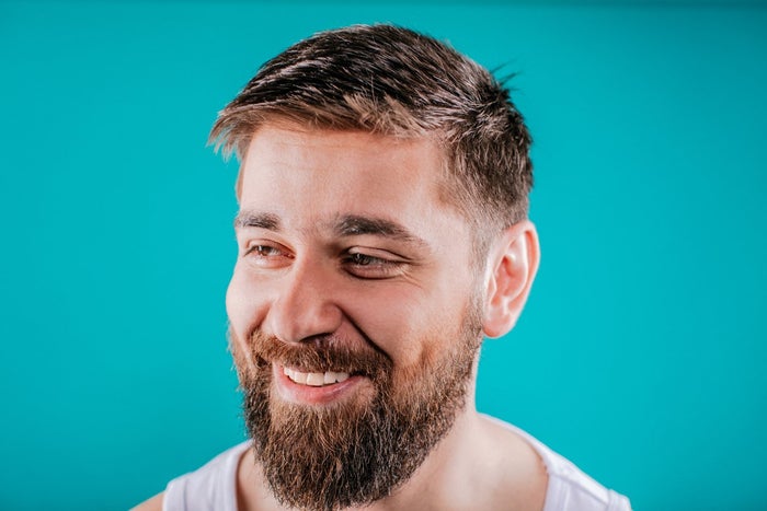 Bearded man smiling after applying King C. Gillette Beard Oil  | Gillette UK