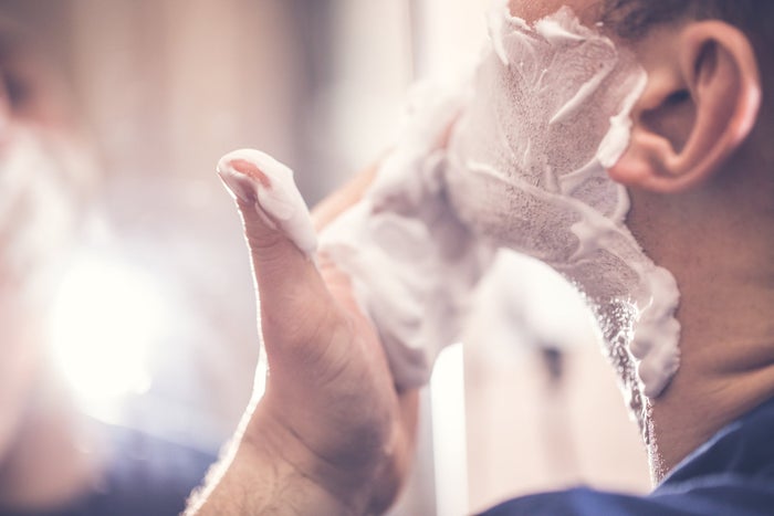 man applying shaving cream before grooming 