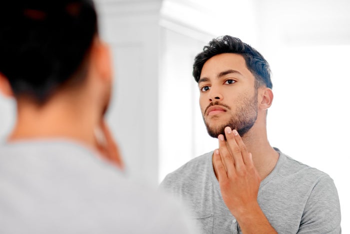 A man inspects his shave in a mirror | Gillette UK