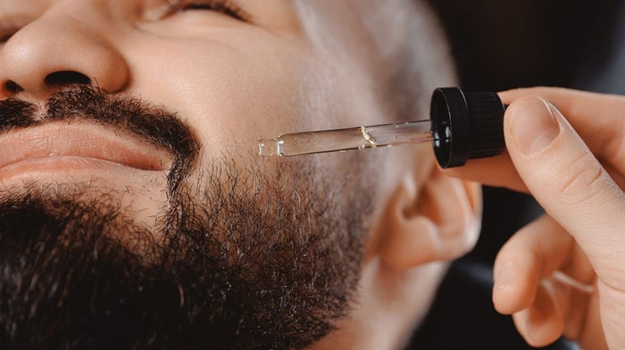 Barber applying beard oil to his client's beard | Gillette UK