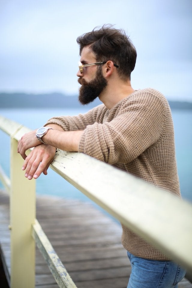 A man leans against a fence with his neatly trimmed long beard | Gillette UK