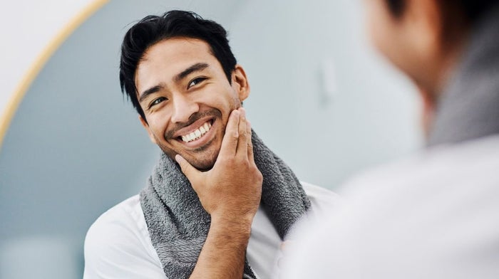 A man smiling in a mirror after a successful shave | Gillette UK 