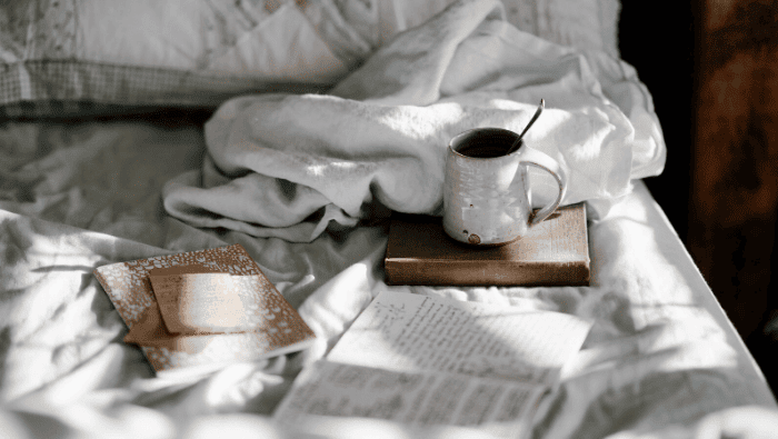 book and mug on bed