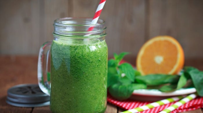 green juice in jar with paper straw