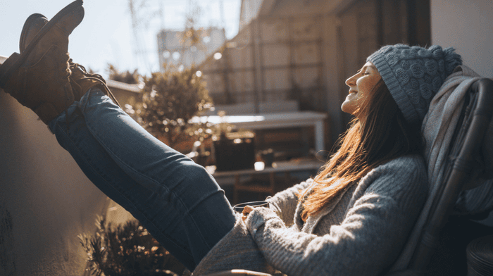 woman enjoying winter sun with her legs up