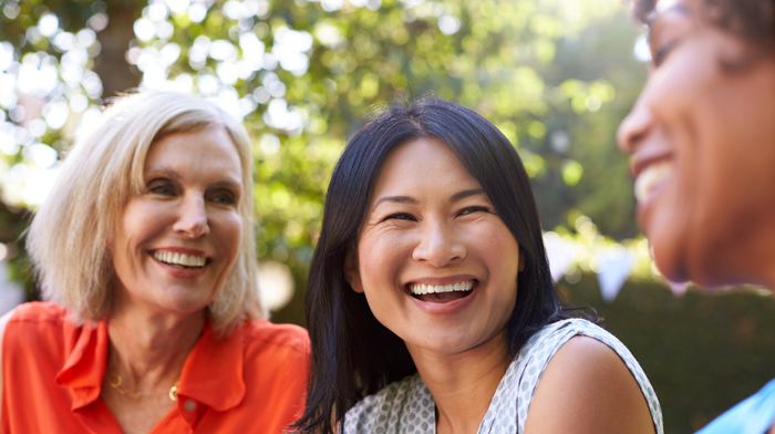 mature women smiling together outdoors