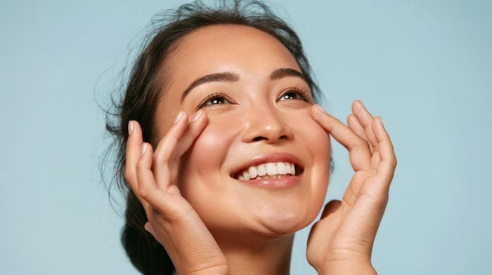 A young woman with perfectly prepped skin, ready to do soft glam.