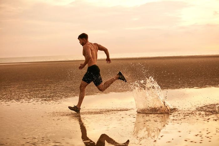 Muž běžící po pláži