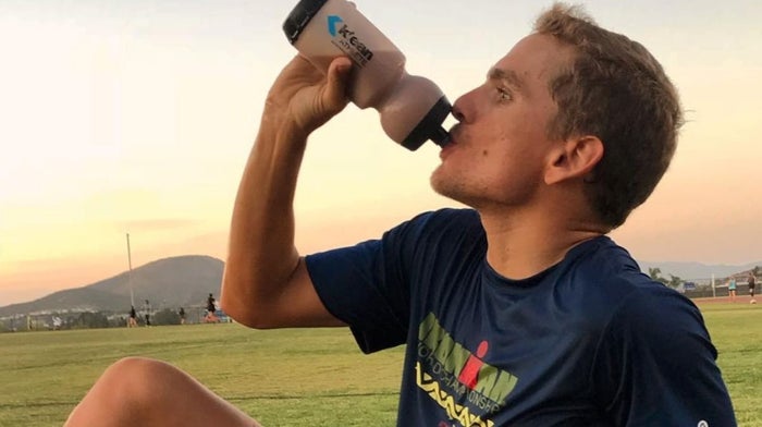 man consuming a protein shake while exercising