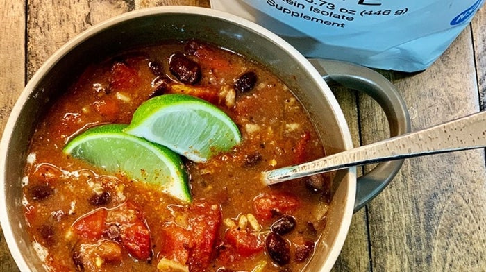 Birdseye view of black bean soup with lime wedge garnish