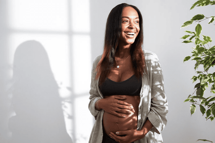 Mum smiling holding baby bump