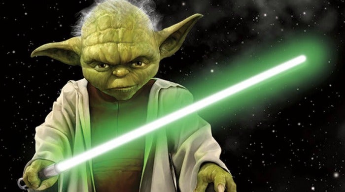 Yoda holding a green lightsaber.