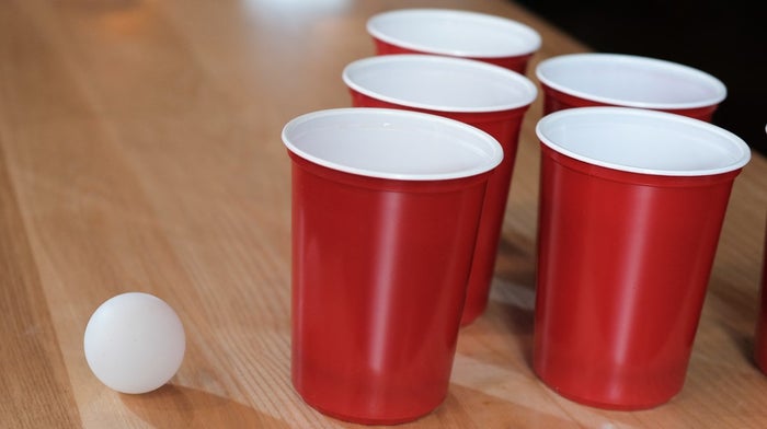 beer pong cups on table with ball