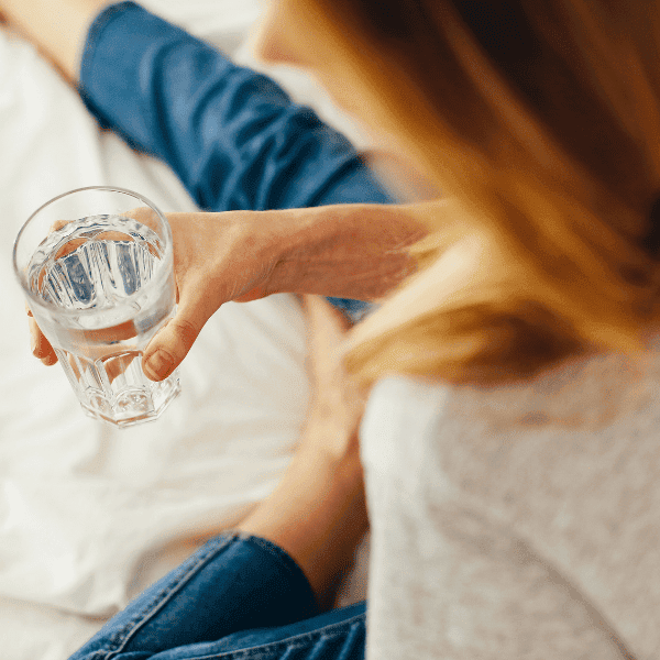 woman holding water in bed