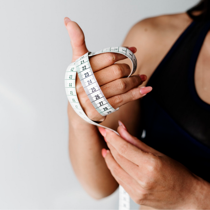 lady wrapping tape measure around hand