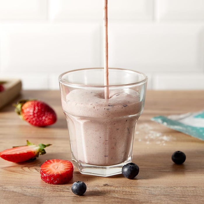 berry smoothie being poured into glass