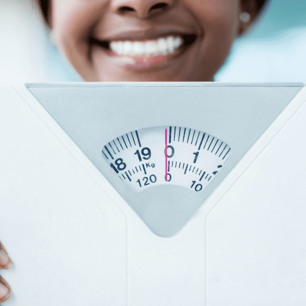 lady smiling and holding scales