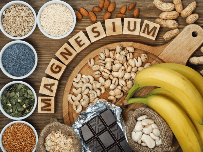 A spread of magnesium foods accompanied by the word Magnesium spelled out with scrabble letters