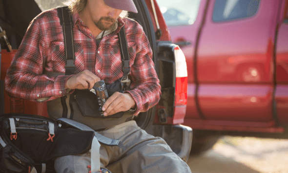 A man eating an IdealRaw Organic Protein bar in the back of the car